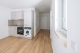 Wohnbereich & Küche - Zentrale 2-Zimmer-Neubauwohnung mit Terrasse und Gartenanteil!